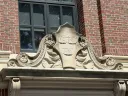 Architectural stonework featuring floral motifs and an inscription reading Veritas, set against the brick exterior of Widener Library.