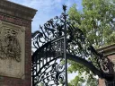 Johnston Gate at Harvard University with green foliage behind it 