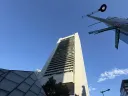 Tall modern skyscraper against a clear blue sky, viewed from below.