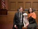 Chris Green and Kristen Stilt in Austin Hall’s Ames courtroom with Lola, Stilt’s rescue dog from Egypt