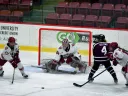 Photograph of several players competing for the puck in front of the Harvard goal