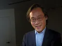 Frank Hu holds a plate filled with food. 