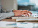 Hands typing on a computer keyboard.