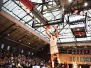 Chris Ledlum dunks the ball in the basket as opposing players trail behind him