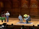 Martin Luther King III and Brandon Terry seated in chairs on a large auditorium stage