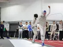 A fencer walks away from his opponent, holding up a fist