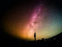 silhouette of person looking up from the ground at sky 