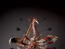 In Yup’ik lore, the crane—depicted in the mask above—connotes stealth, power, and insight. The human face on the bird’s belly represents its <em>yua,</em> or spirit—the part of the animal that understands, and can relate to, humans. The porcelain “teeth” that border the face are a reminder to use one’s innate gifts to good effect, or risk being consumed by them. The porcelain “bones” hanging from the wings ward off evil spirits; wooden rings represent this world and the spirit world.