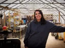 Usha Thakrar standing in the greenhouse production center at Stonefield Farm
