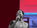 A photo of rapper Meek Mill next to an empty stage displaying the name of the panel