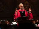 Adam Falk delivering his talk in academic robes