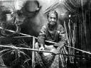 Darden preparing river-cane splints for weaving, c. 1900.