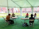 Photograph of teaching a playwriting class under a tent outdoors
