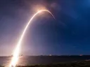 A time-lapse exposure of the SpaceX rocket carrying TEMPO into orbit reveals an arc of light against the sky.