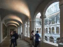 A few visitors in the arcade overlooking the Calderwood Courtyard of the Harvard Art Museums