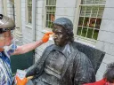 Conservators from Skylight Studios work on the John Harvard statue
