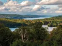 sweeping aerial view of blue sky and Quabbin Reservoir water and mountains 