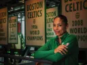 Allison Feaster wearing a green Celtics shirt in front of team championship banners