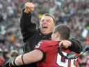 Defensive line coach Michael Horan and reserve tackle Adam Riegel ’13 share a jubilant hug after a 34-24 victory in The Game.