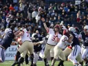 Luke Emge throws the football amidst Yale defenderss