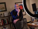 Arthur Brooks stands behind a chair in his office, smiling
